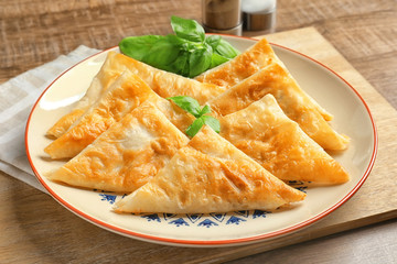 Plate with delicious samosas on table