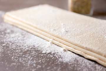 Flaky dough sheets on table, closeup