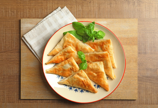 Plate with delicious samosas on table