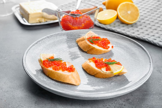 Sandwiches with red caviar, butter and lemon on plate