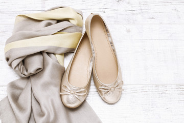 Ballerina flats and soft scarf on white wood