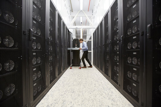 Staff of bitcoin storage system service examining hardware in mining farm