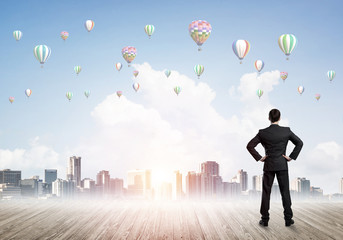 Motivation and inspiration concept with modern cityscape and businessman observing it