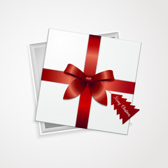 Gift box Vector White gift box with red ribbon and red label in the form of a Christmas tree with the inscription Merry Christmas are lying on a white background Modern realistic style Top view