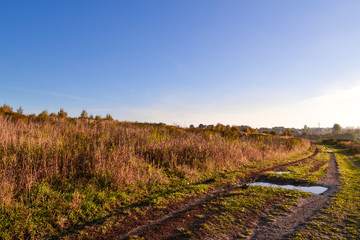 Bad rough road with puddles after the rain. Countryside. Russia