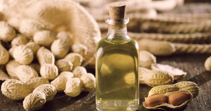 Macro shot, peanuts and a drop of oil falling on them, as a symbol of a genuine peanut oil and good, great for frying. Concept: bio, peanuts, fries.