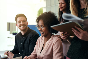 Smiling group of diverse businesspeople working together in an office