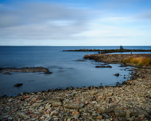 sea vänern cliffs stones pier water blue clouds lake 