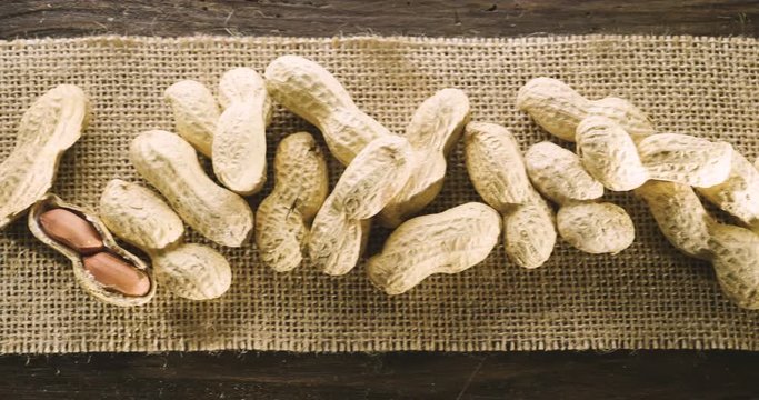 Macro shot, peanuts and a drop of oil falling on them, as a symbol of a genuine peanut oil and good, great for frying. Concept: bio, peanuts, fries.
