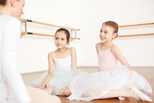 Cute little ballerinas listening to their teacher advice before stage performance