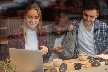 Attractive blonde pointing at her laptop