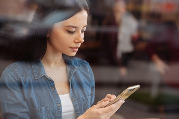 Concentrated girl looking at her telephone