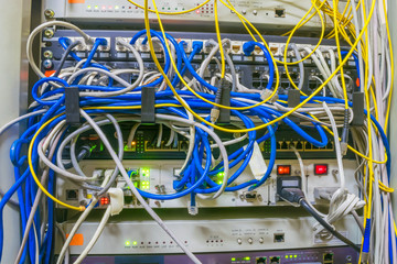 Messy wires are in a rack with servers and Internet equipment