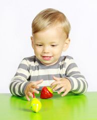 Fototapeta na wymiar Ein einjähriger Junge spielt mit Holzspielzeug