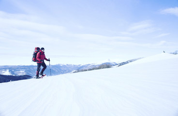 Winter hike in the mountains with a backpack and tent.