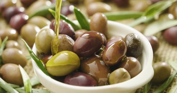 Genuine Italian organic oil cold pressed in slowmotion falls on organic bread. concept of nature and healthy food, healthy and natural. fresh olives and Tuscan Italian oil