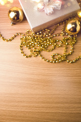 gift box with gold bead necklace on wood background