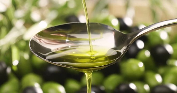 Genuine Italian organic oil cold pressed in slowmotion falls on organic bread. concept of nature and healthy food, healthy and natural. fresh olives and Tuscan Italian oil