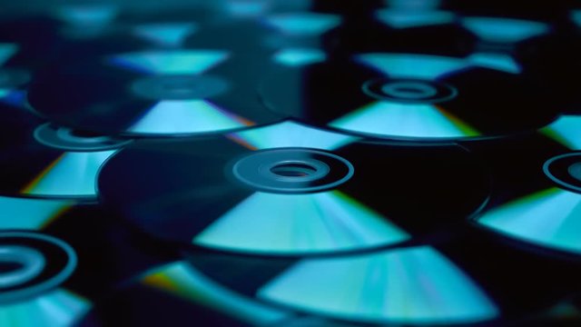 Many compact discs lying on top of each other rotate. Macro. Closeup. Shallow depth of field
