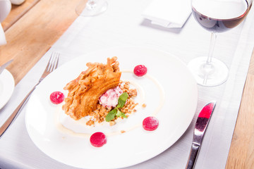 Polish-Lithuanian traditional spit cake ('tree cake') -sekacz (polish) or sakotis (lithuanian) with ice-cream, roasted nuts and raspberry jelly decorated wtih fresh mint served in a restaurant