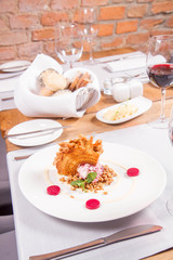 Polish-Lithuanian traditional spit cake ('tree cake') -sekacz (polish) or sakotis (lithuanian) with ice-cream, roasted nuts and raspberry jelly decorated wtih fresh mint served in a restaurant