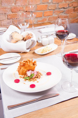 Polish-Lithuanian traditional spit cake ('tree cake') -sekacz (polish) or sakotis (lithuanian) with ice-cream, roasted nuts and raspberry jelly decorated wtih fresh mint served in a restaurant