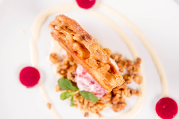 Polish-Lithuanian traditional spit cake ('tree cake') -sekacz (polish) or sakotis (lithuanian) with ice-cream, roasted nuts and raspberry jelly decorated wtih fresh mint