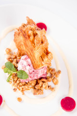 Polish-Lithuanian traditional spit cake ('tree cake') -sekacz (polish) or sakotis (lithuanian) with ice-cream, roasted nuts and raspberry jelly decorated wtih fresh mint