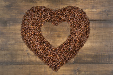 Heart of coffee beans on a wooden surface