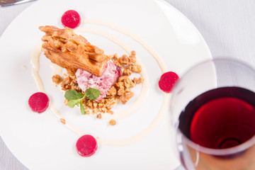 Polish-Lithuanian traditional spit cake ('tree cake') -sekacz (polish) or sakotis (lithuanian) with ice-cream, roasted nuts and raspberry jelly decorated wtih fresh mint served in a restaurant