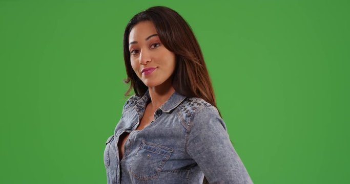 Portrait of beautiful Latina female standing laughing at camera on green screen. On green screen to be keyed or composited. 