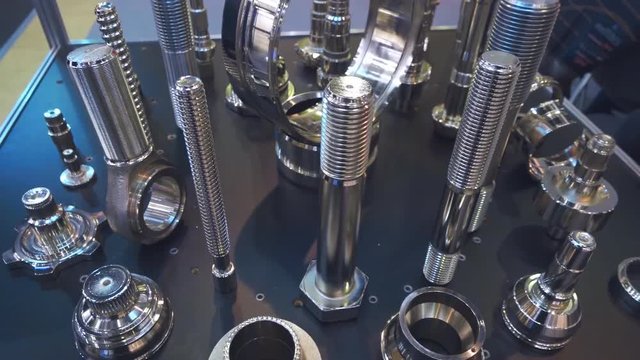 Samples of large industrial and small for domestic use of metal bolts. Chromed bolts and other details shine on the stand