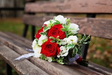 Beautiful wedding bouquet on the bench in the park