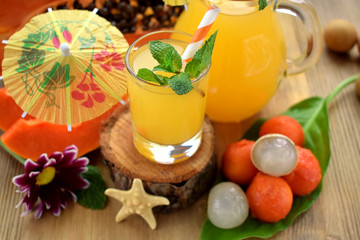 Yellow beverage decorated with straws and little cocktail umbrellas in glass vessels