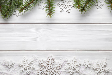 Christmas background - spruce tree and snowflakes on white wooden table