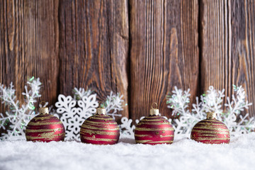 Christmas background - baubles and snowflakes on snow and wooden wall