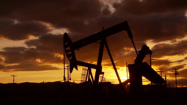 Oil well piston pumps at sunset