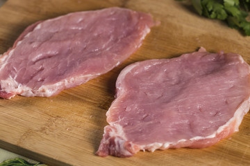 Two pieces of raw pork meat beaten to make schnitzels