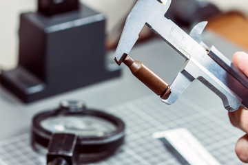 Measurement of a cartridge from a firearm with a caliper rule. Forensic laboratory. Ballistic examination.