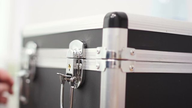 The Man Opens The Locks on the Case