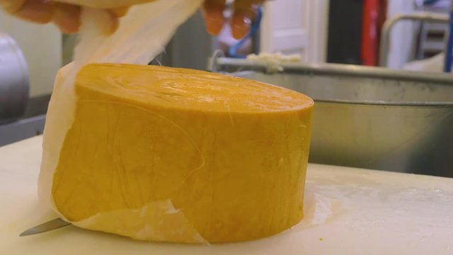 Cheese being prepared for sale. Two clips