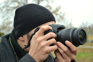 A guy with a camera in the autumn on the street