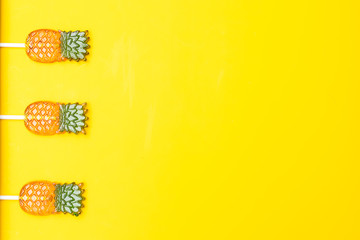 Sweet candy in the form of pineapple on a yellow background. Flat lay