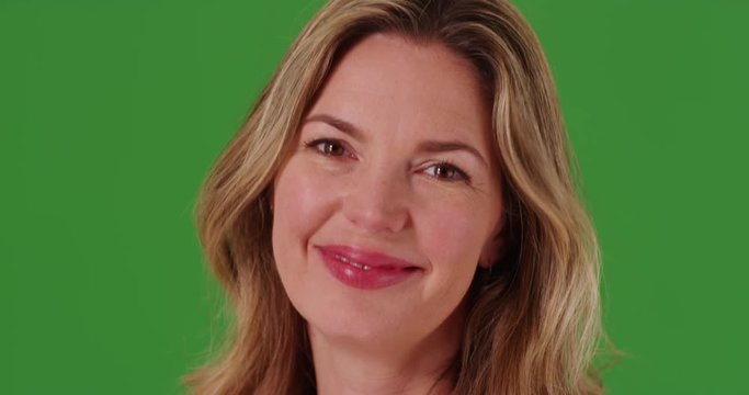 Middle aged Caucasian woman laughing at camera on green screen. On green screen to be keyed or composited.