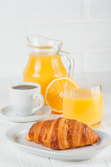 Freshly baked croissant, orange juice, fresh fruits, jam on white wooden background. French breakfast. Fresh pastries for morning. Delicious dessert. Closeup photography. Vertical banner
