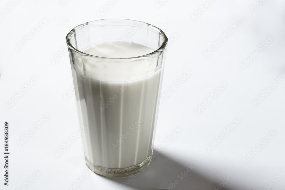 Wall mural A glass of milk on white background closeup