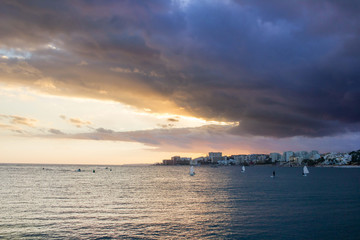 Naklejka na ściany i meble Sunset in sea with dramatic cloudy Malaga sky