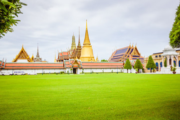 Naklejka premium Royal palace in Bangkok, green grass and grey sky on the background