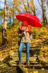 Woman walking in park with umbrella