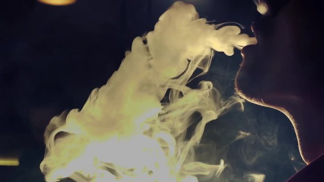 Young man smoking hookah in a bar